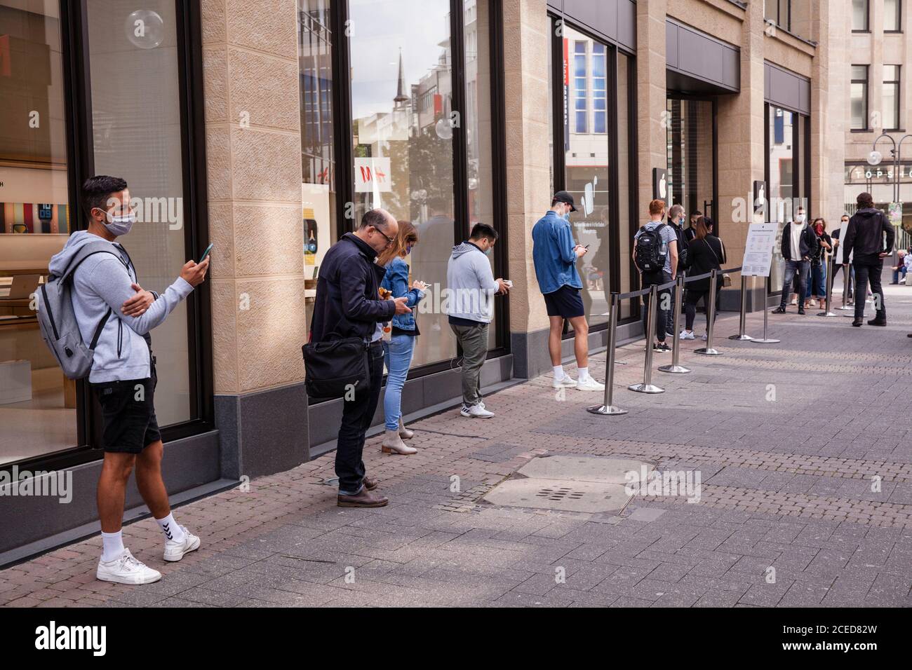 to comply with the distance rules during the Corona pandemic, customers are waiting in front of the Apple Store on Schildergasse, Cologne, Germany.  z Stock Photo