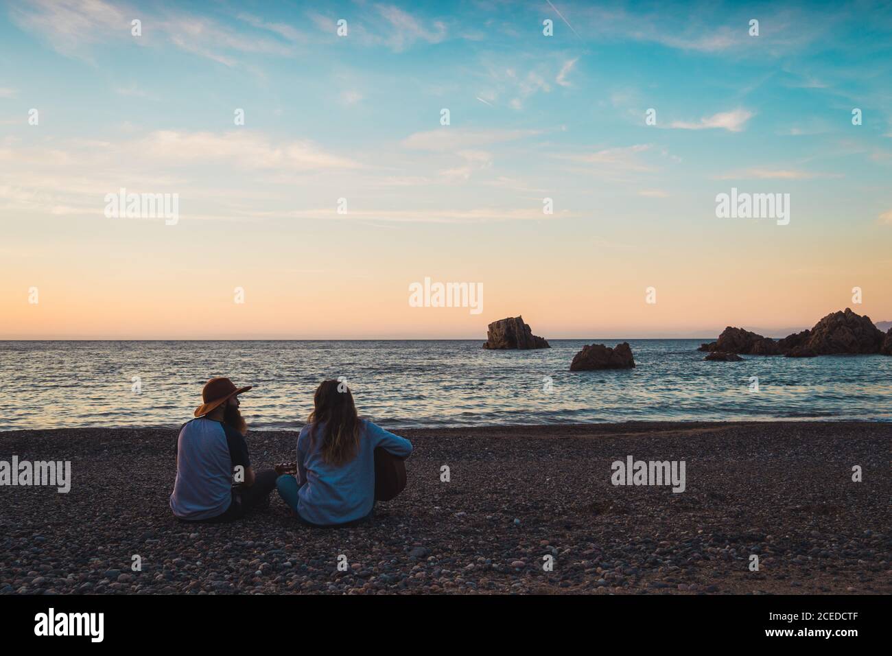 Couple with guitar on beach Stock Photo