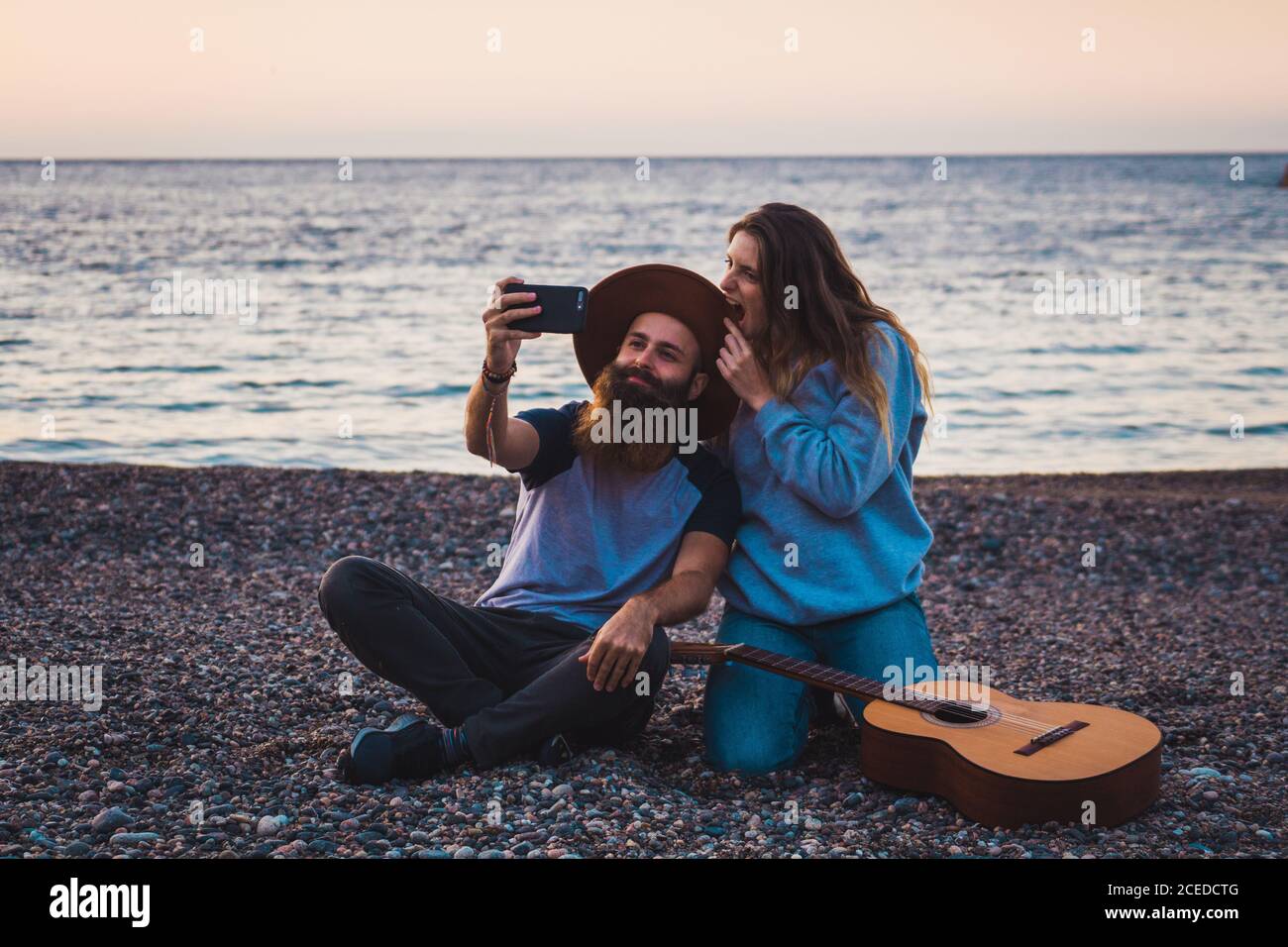 Couple with guitar on beach Stock Photo