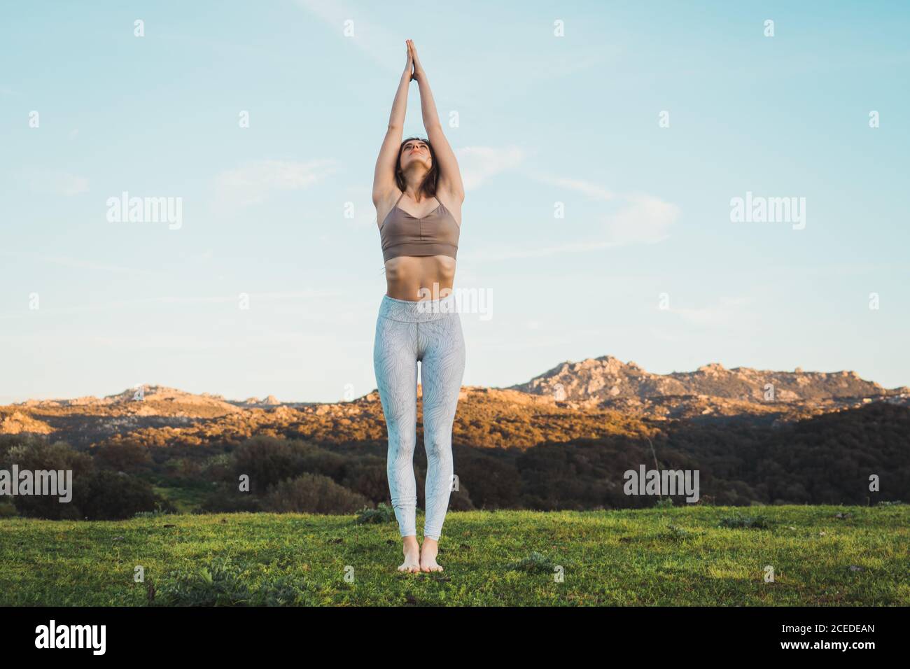 Woman meditating on field Stock Photo
