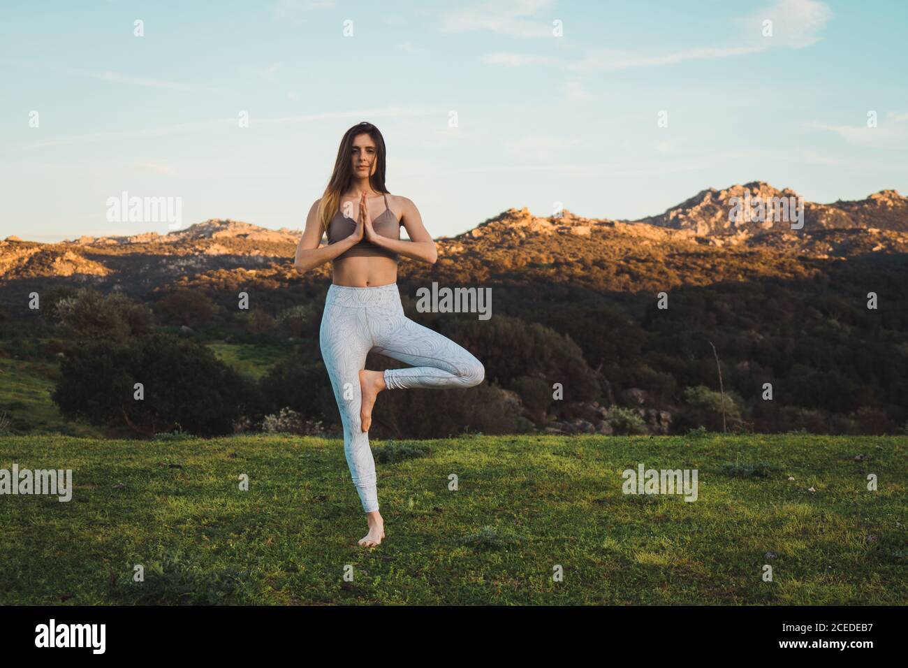 Woman meditating on field Stock Photo