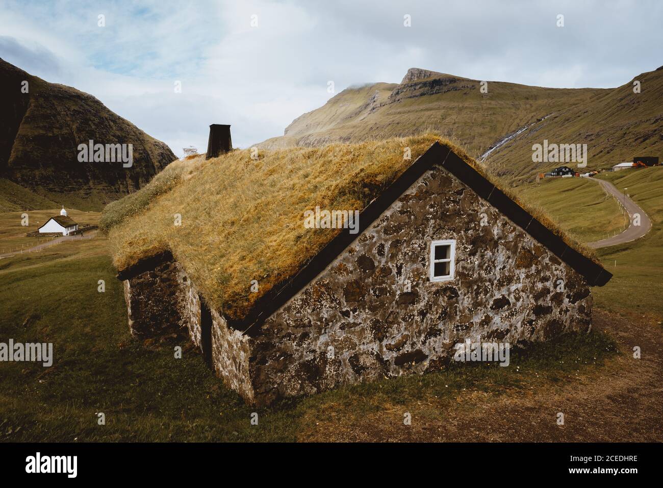 Stone built rural house with grass on roof in hillside in Feroe Island Stock Photo