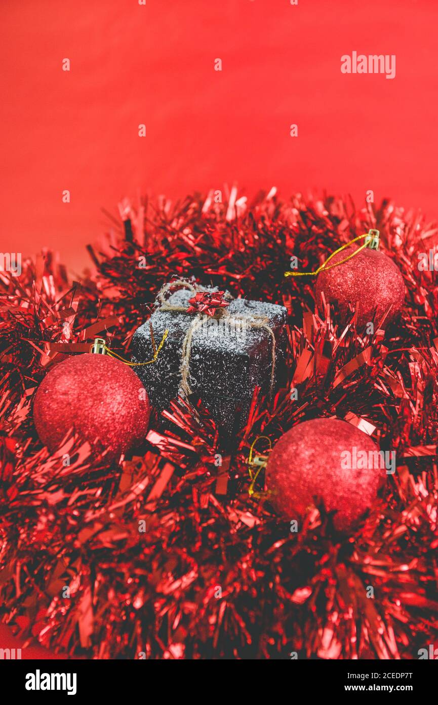 a christmas gift with snow in a red tinsel Stock Photo