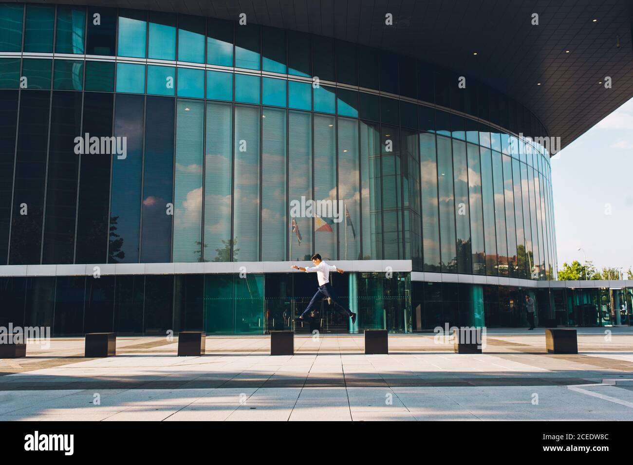 man jumping on pavement of highrise Stock Photo