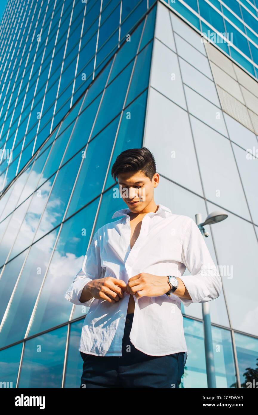 Handsome man in white shirt against skyscraper Stock Photo