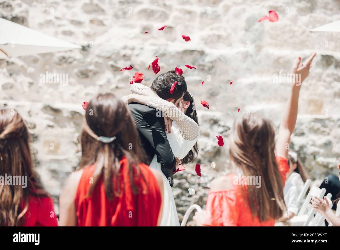 Young fiance and bride kissing each other at wedding ceremony under