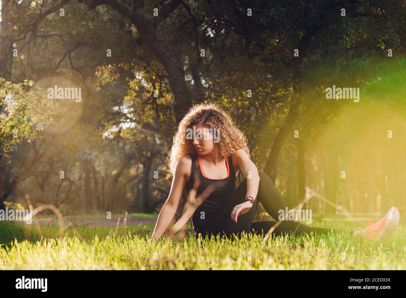 Happy Woman stretching on sunny meadow Stock Photo