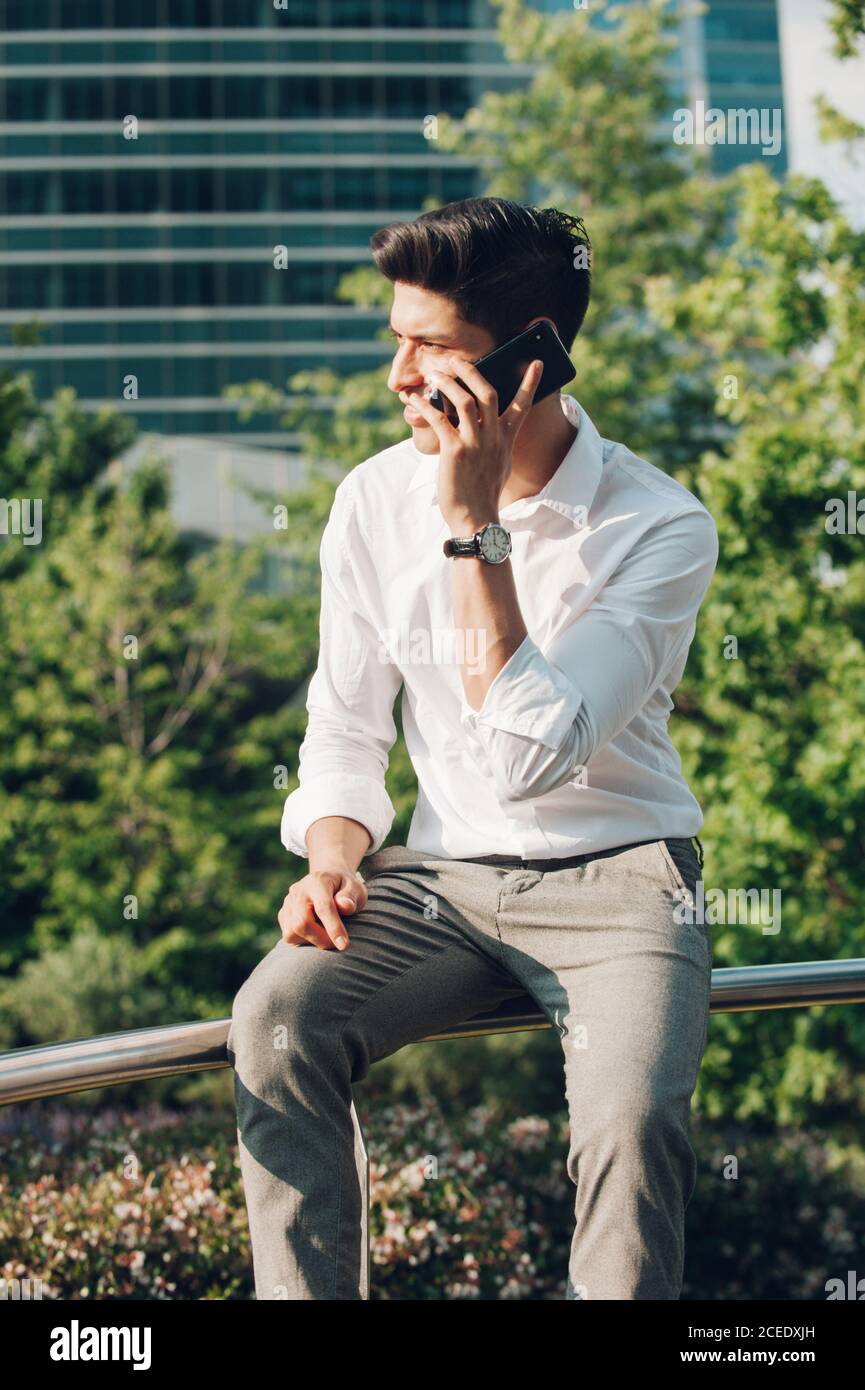 Young man talking phone on railing Stock Photo