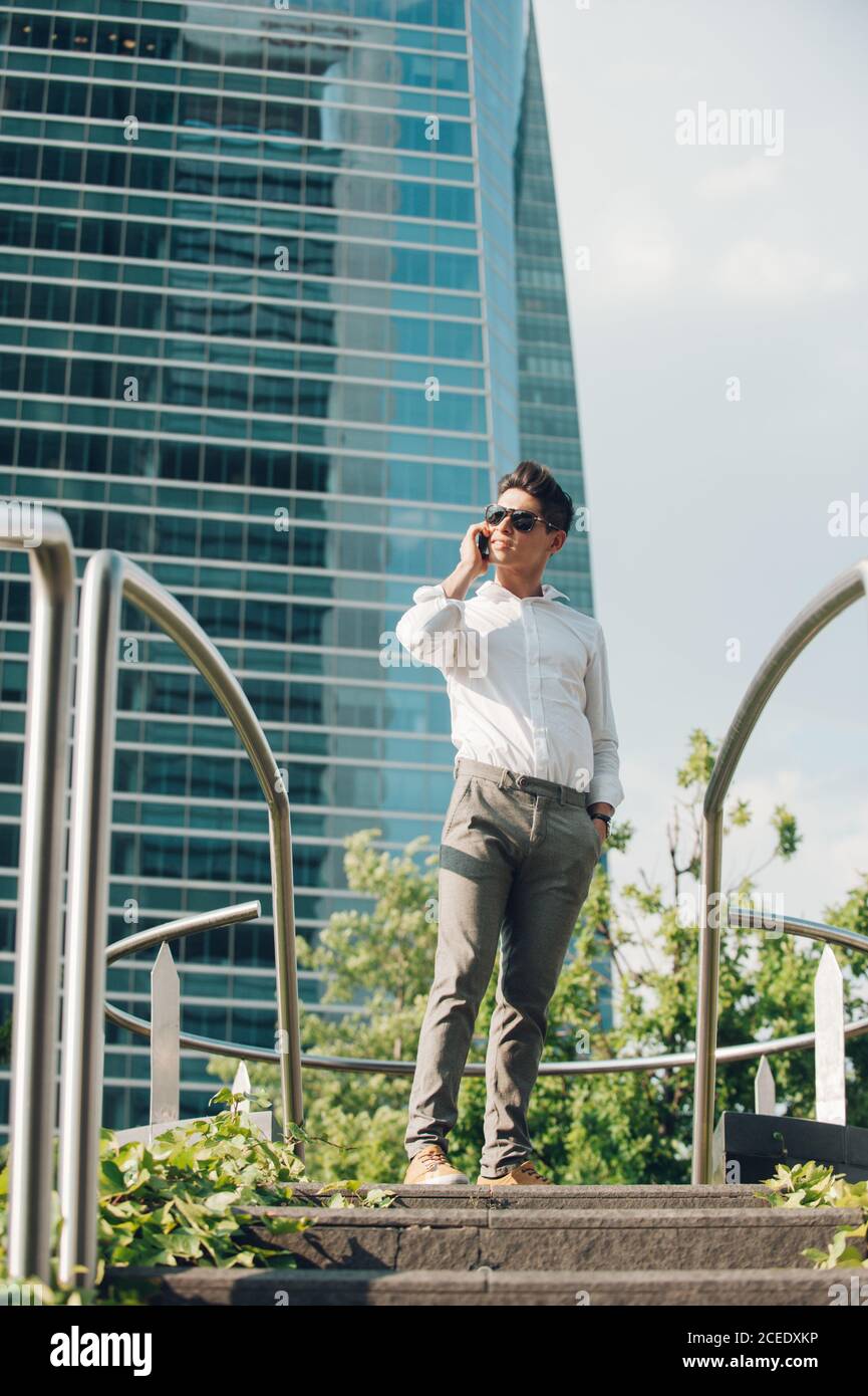 Cheerful man with smartphone walking down steps Stock Photo