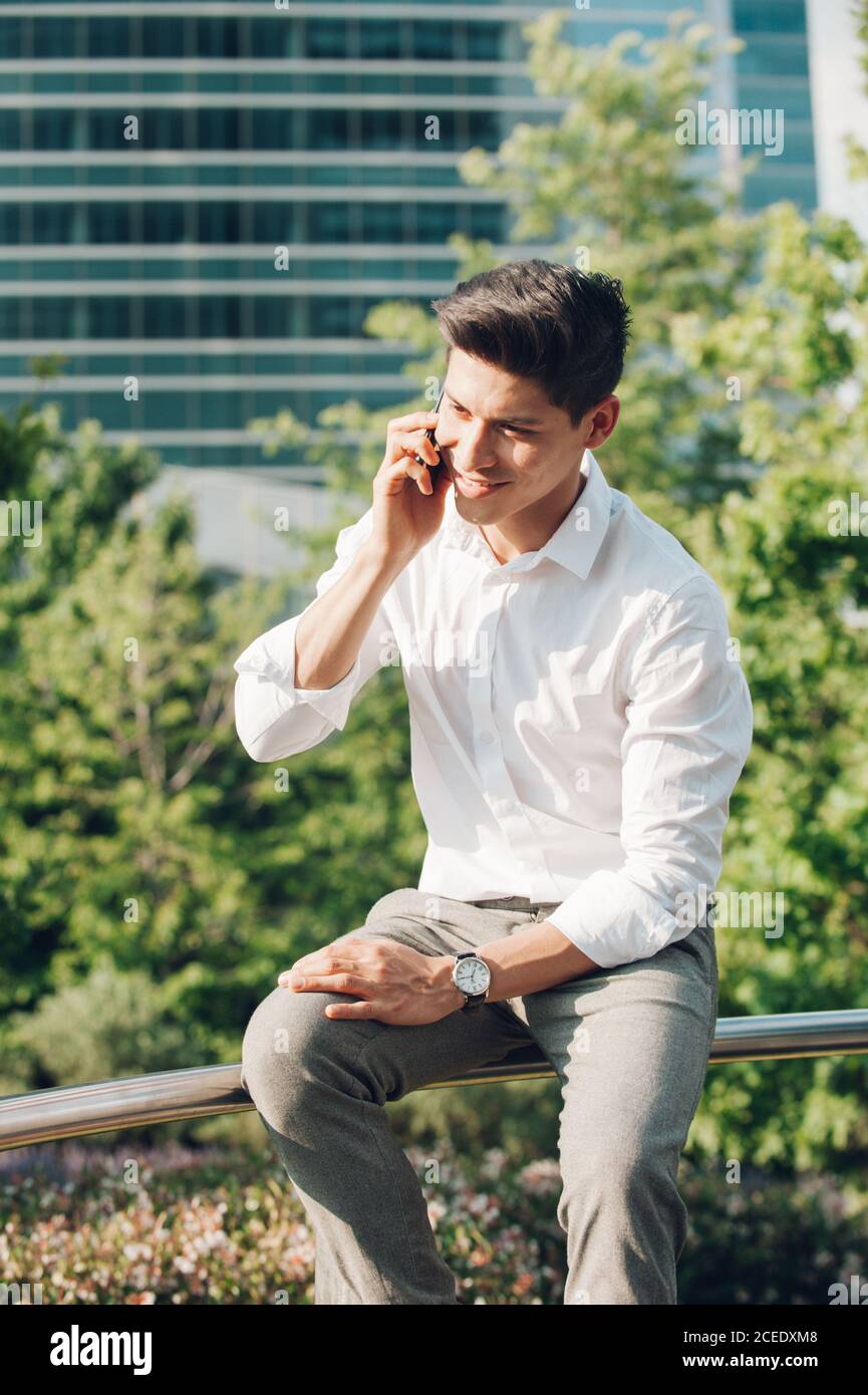 Young man talking phone on railing Stock Photo