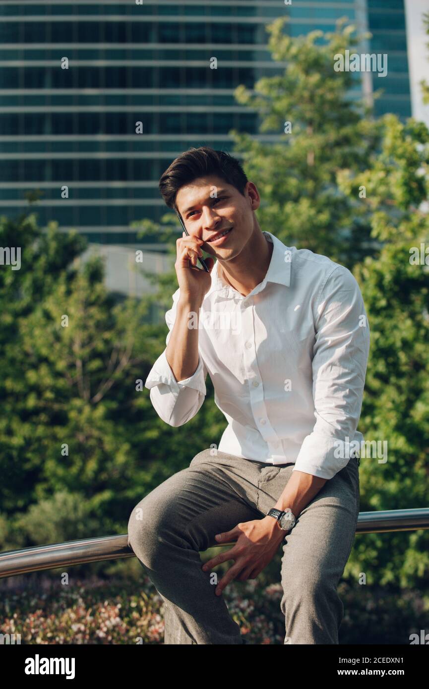 Young man talking phone on railing Stock Photo