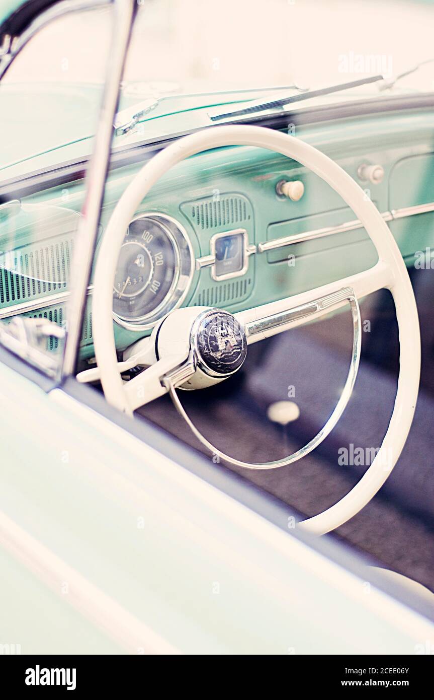 Retro vehicle with white helm and green old fashioned interior†with chromium-plated details and obsolete steering in soft focus Stock Photo