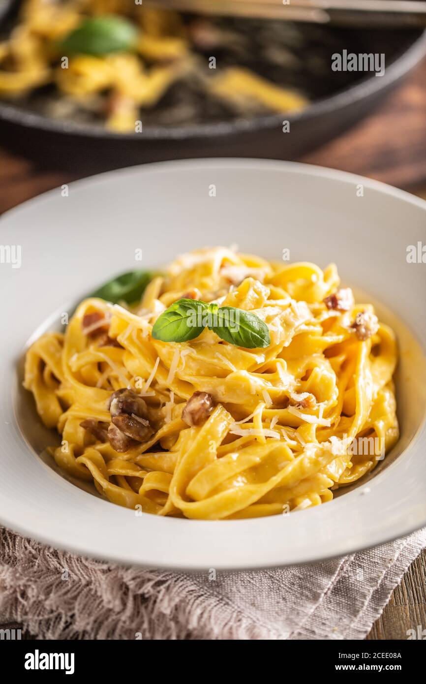 Italian food pasta tagliatelle carbonara with pancetta parmesan egg yolk and basil leaves Stock Photo