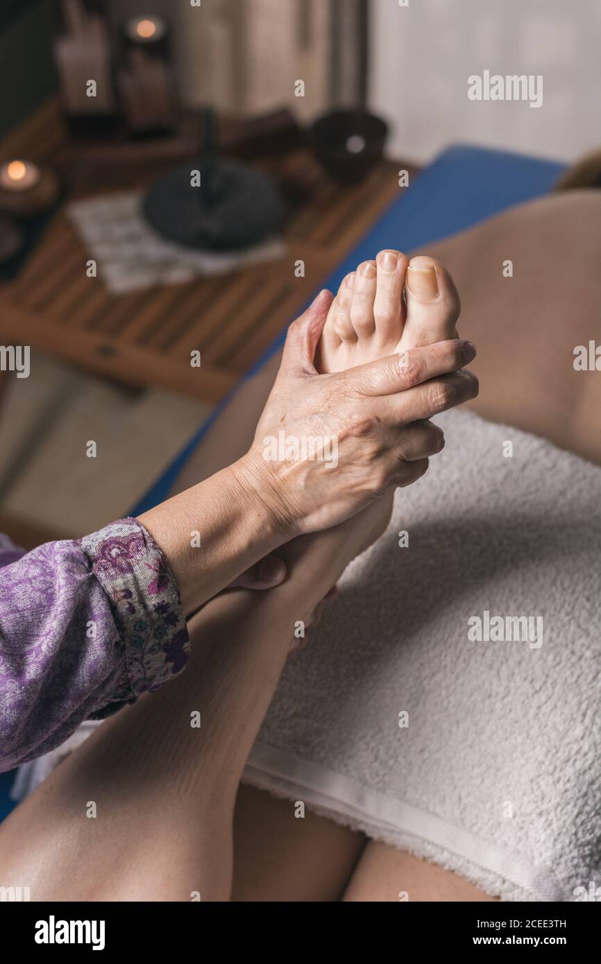 Therapist doing foot reflexology massage on patient. Treatment to