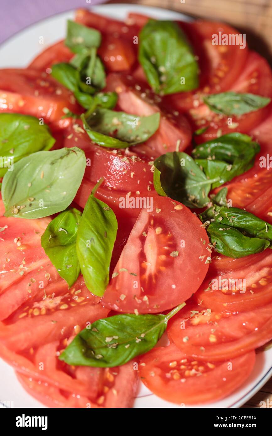 sliced of tomatoes with basil Stock Photo - Alamy