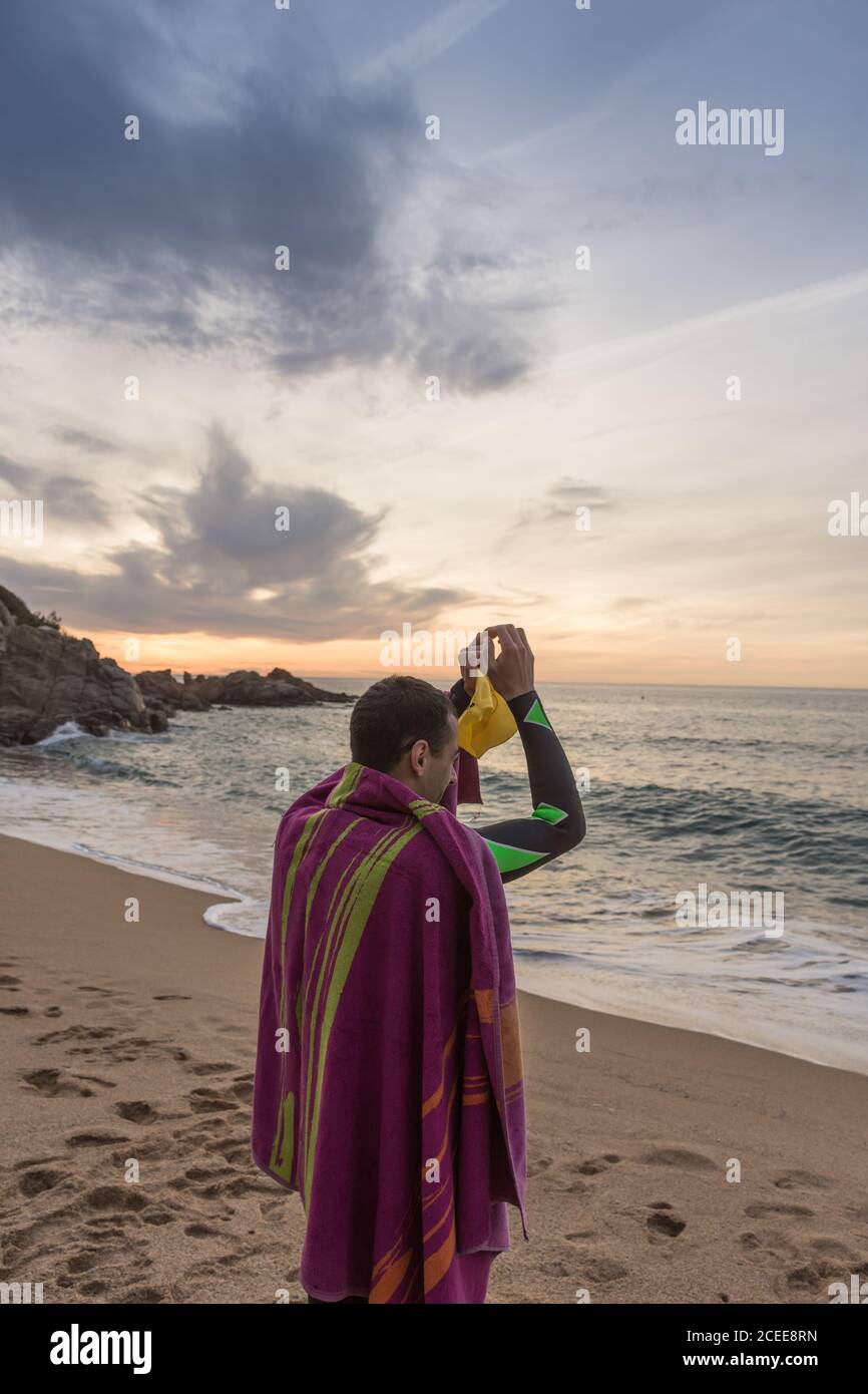 Triathlete training for the ironman at sea with his neoprene on a spring dawn Stock Photo