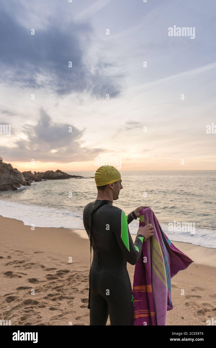 Triathlete training for the ironman at sea with his neoprene on a spring dawn Stock Photo