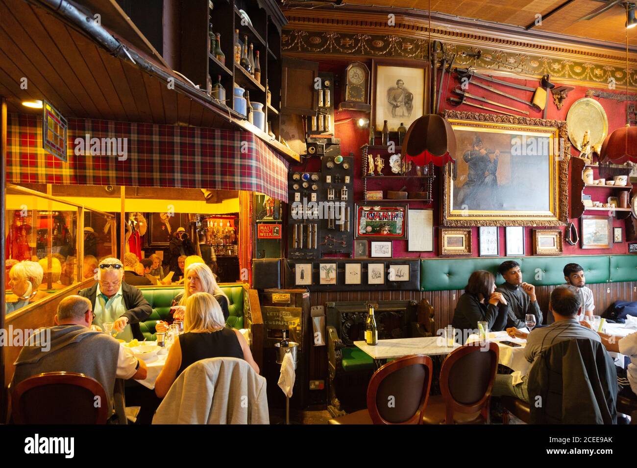 Edinburgh pub; people sitting eating and drinking in The Canny Mans, a pub and restaurant with unusual interior decor, Edinburgh, Scotland UK Stock Photo