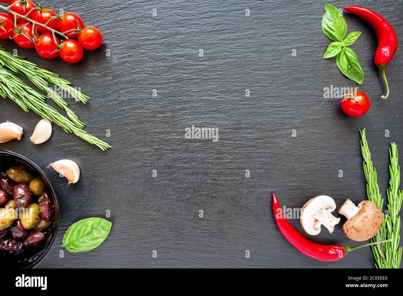 Food ingredients on dark background. Tomatoes, spices, garlic, mushrooms and basil leaves on black background. Vegetarian food, health or cooking conc Stock Photo