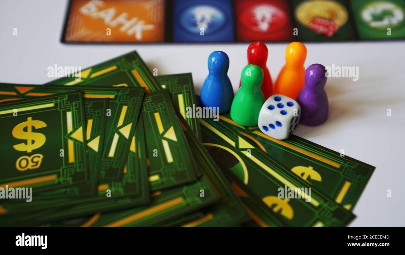 01-09-2020 Minsk,Belarus Board game Monopoly with money and plastic chips. No logos or visible brands - pink background Stock Photo