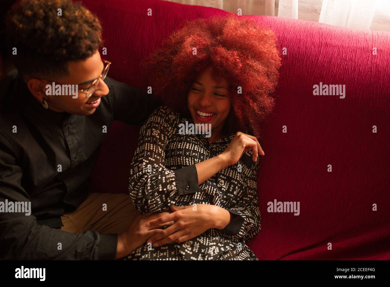 Ethnic couple with sitting on couch Stock Photo