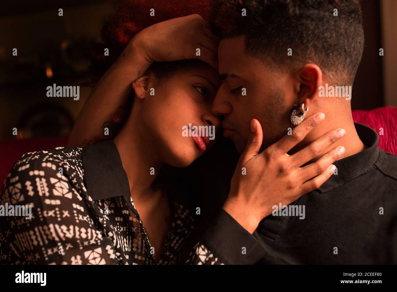 Embracing happy black couple on couch Stock Photo