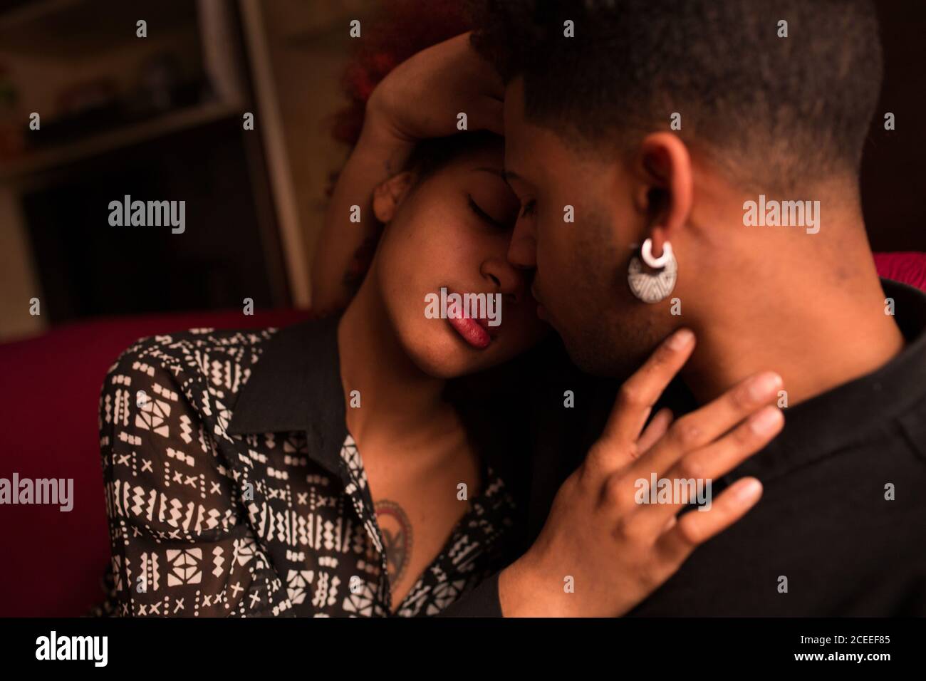 Embracing happy black couple on couch Stock Photo