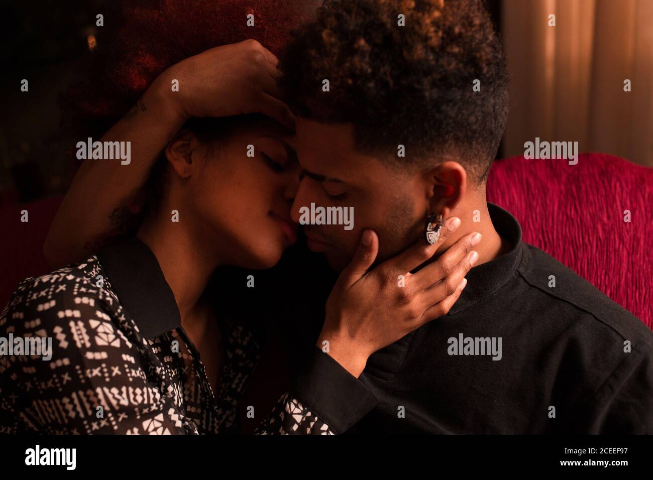 Embracing happy black couple on couch Stock Photo
