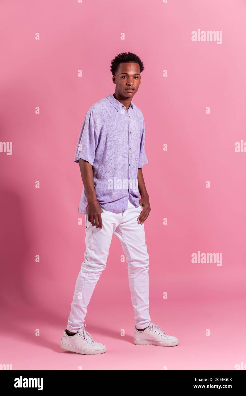 Stylish cheerful young man posing in pink background Stock Photo