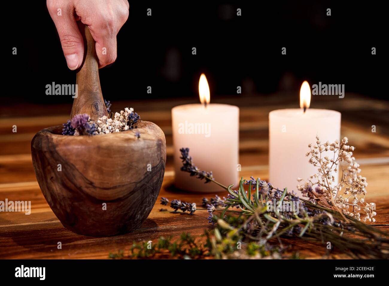 Woman is pulverising healing herbs and flowers into a mortar, ritual cleansing and purification Stock Photo