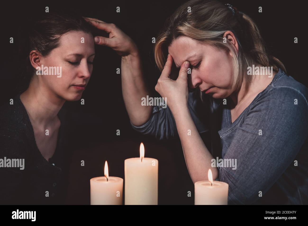 Prophesy and spiritually touching, telepath and esoteric contact, reading and healing, two women and candles Stock Photo