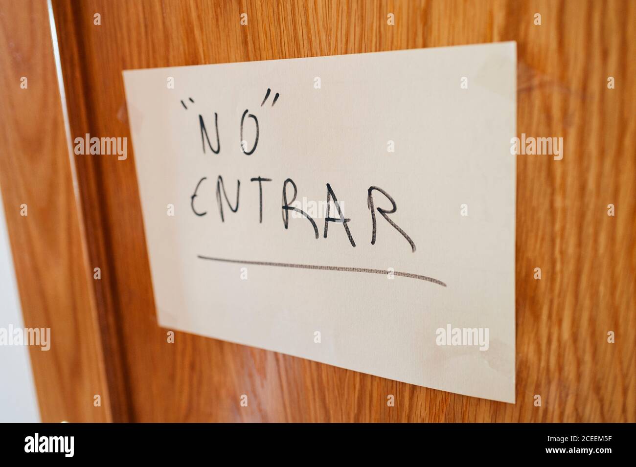 Paper sign with Spanish words and heart on wooden wall. Stock Photo