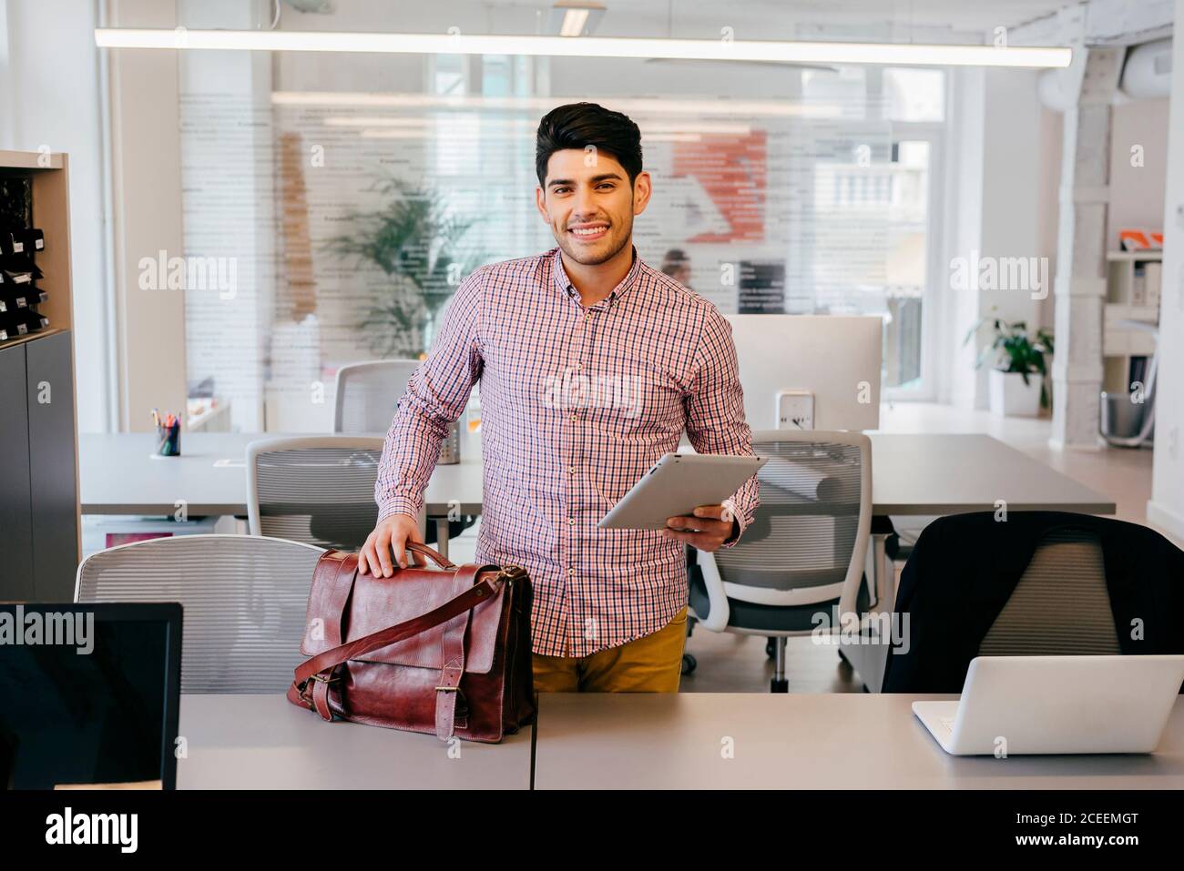 Smiling man with tablet in office Stock Photo
