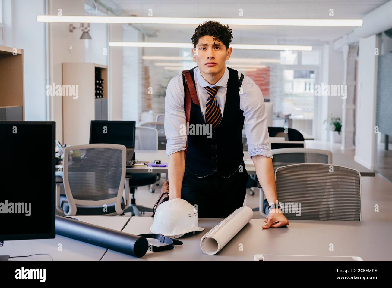 Young man with blueprint in office Stock Photo
