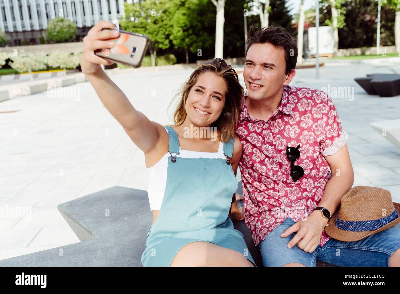 Couple taking selfie on bench Stock Photo