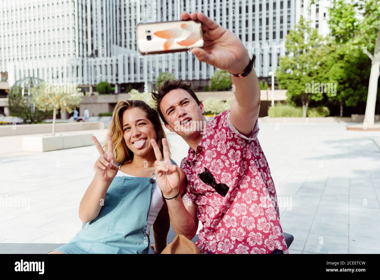 Couple taking selfie on bench Stock Photo