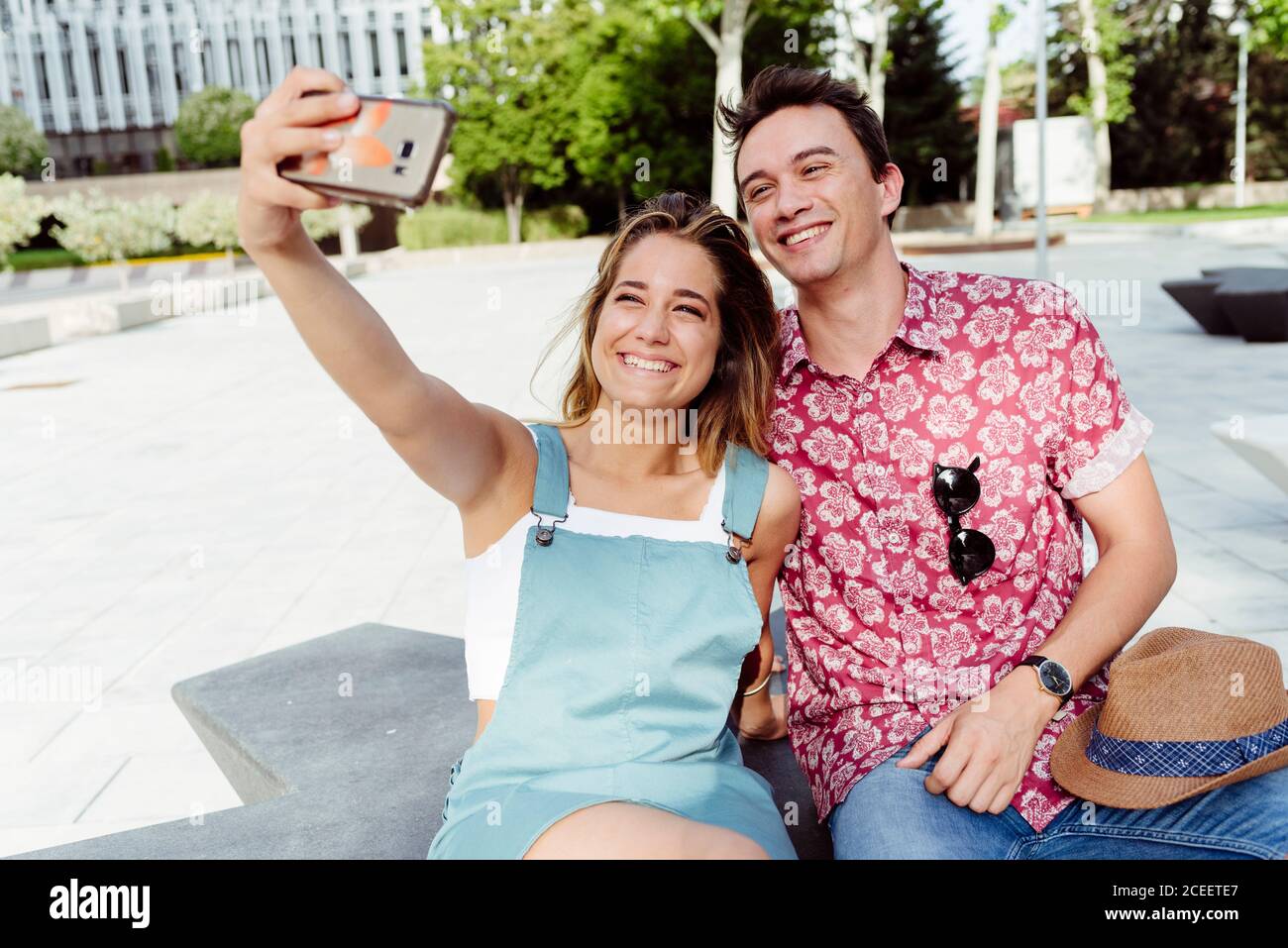 Couple taking selfie on bench Stock Photo
