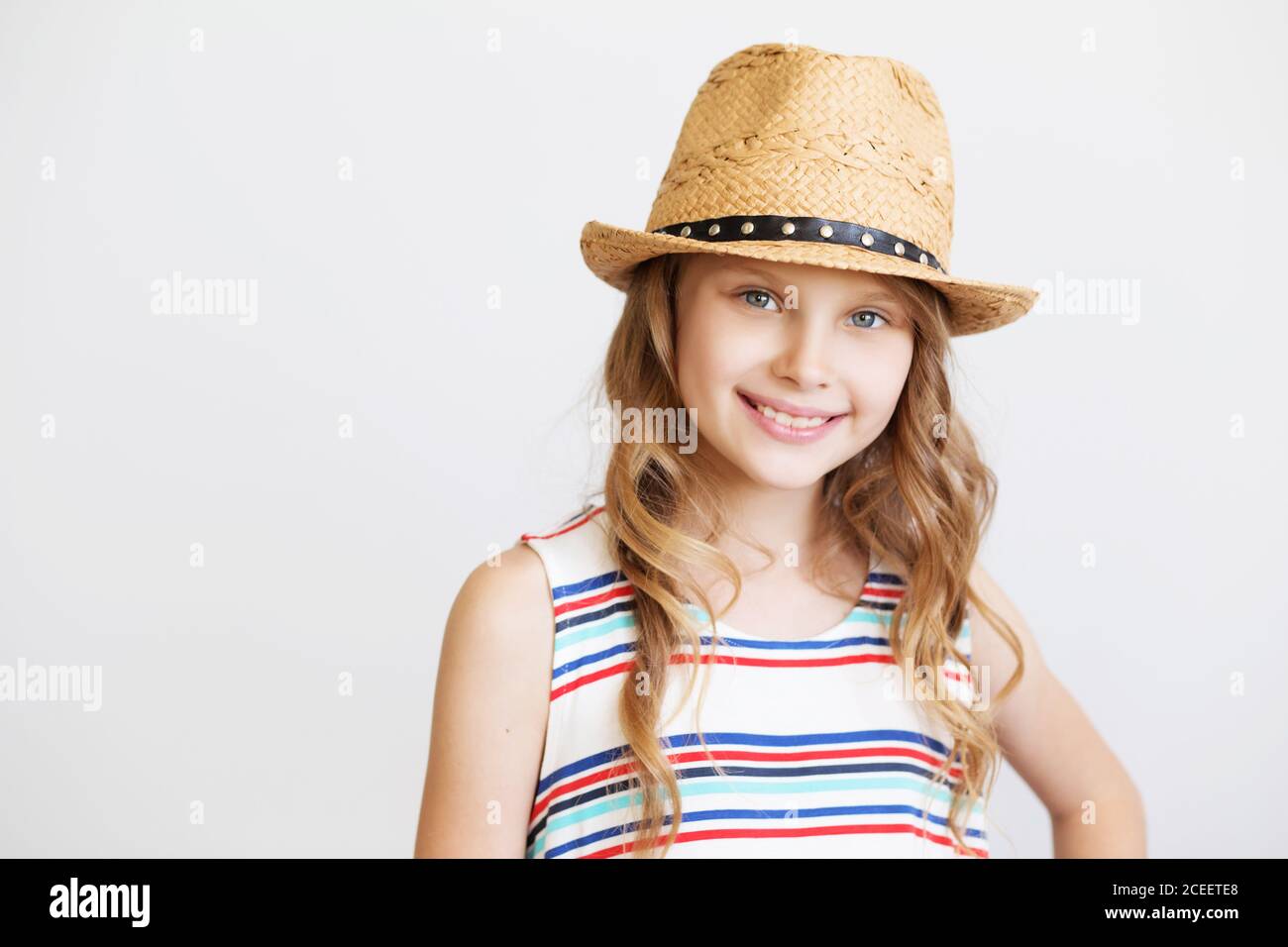 lovely little girl with straw hat against a white background. Smiling ...