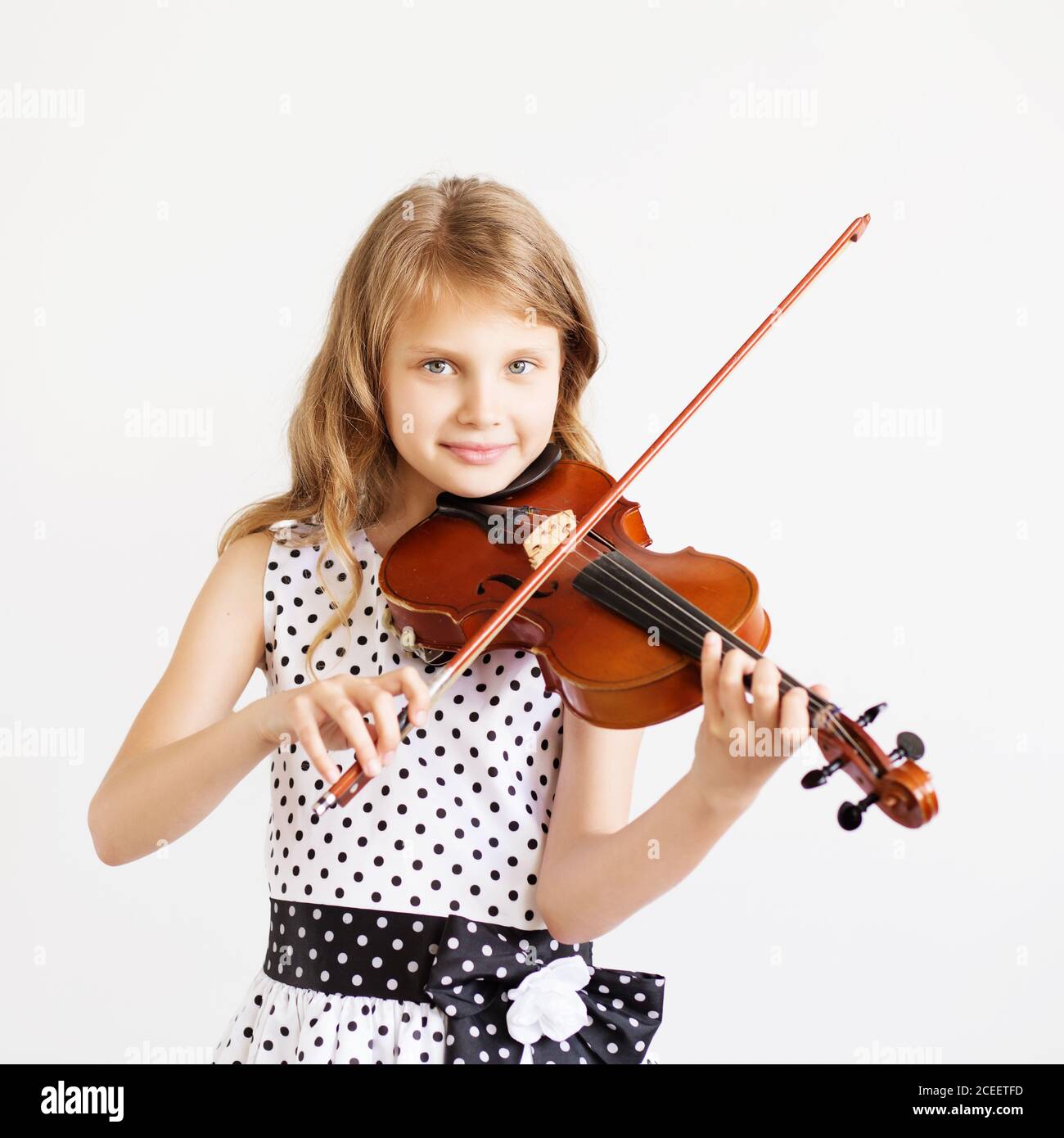Portrait of the little violinist. Beautiful gifted little girl playing ...
