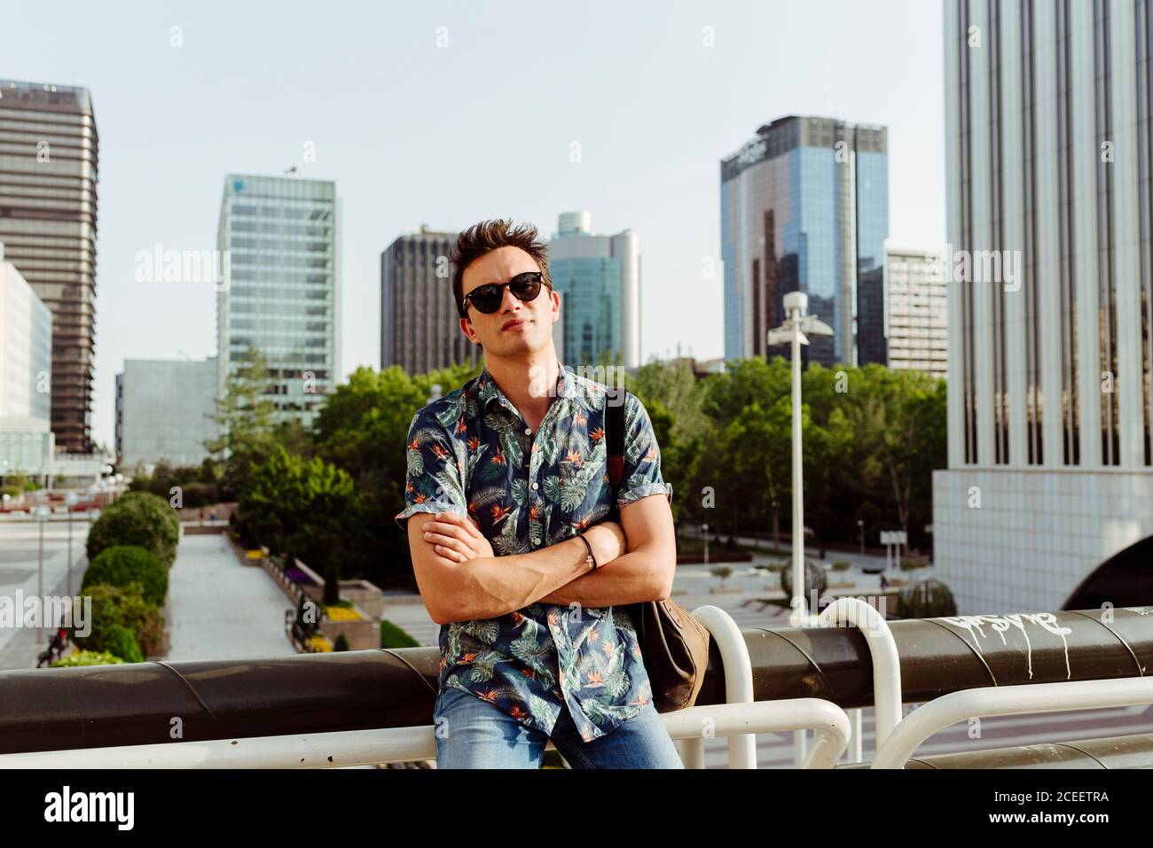 man with arms crossed on bridge Stock Photo