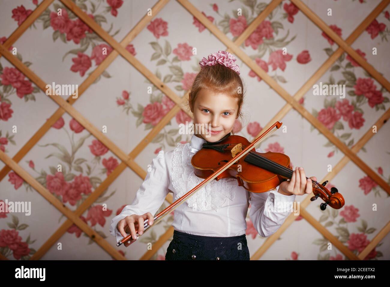 Portrait of the little violinist. Beautiful gifted little girl playing on violin against the background of wallpaper with floral patterns and wooden l Stock Photo - Alamy Portrait of the little violinist. Beautiful gifted little girl playing on violin against the background of wallpaper with floral patterns and wooden l Stock Photo - Alamy