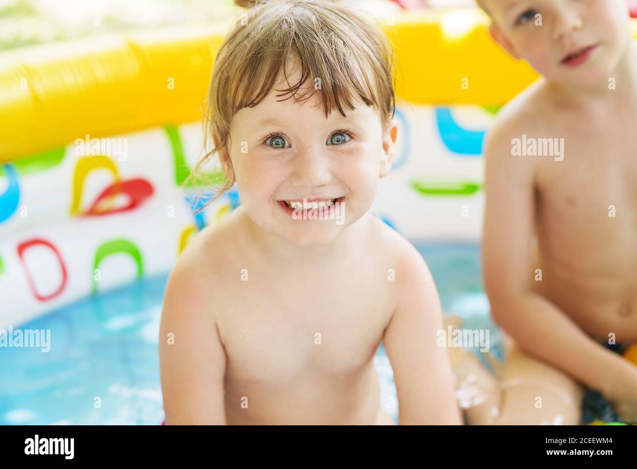 Little children bathe in yellow Inflatable Swimming Paddling Pool