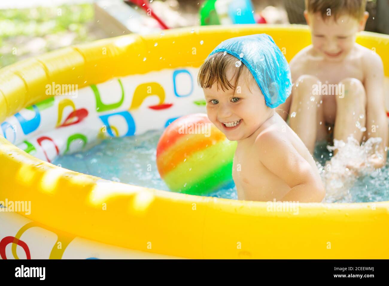 Little children bathe in yellow Inflatable Swimming Paddling Pool