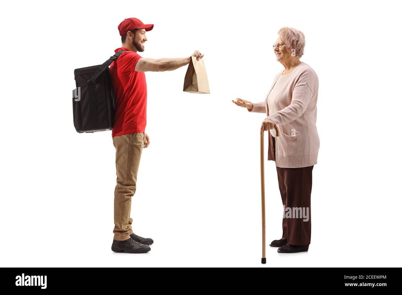 Full length profile shot of a guy delivering a food to an elderly lady isolated on white background Stock Photo