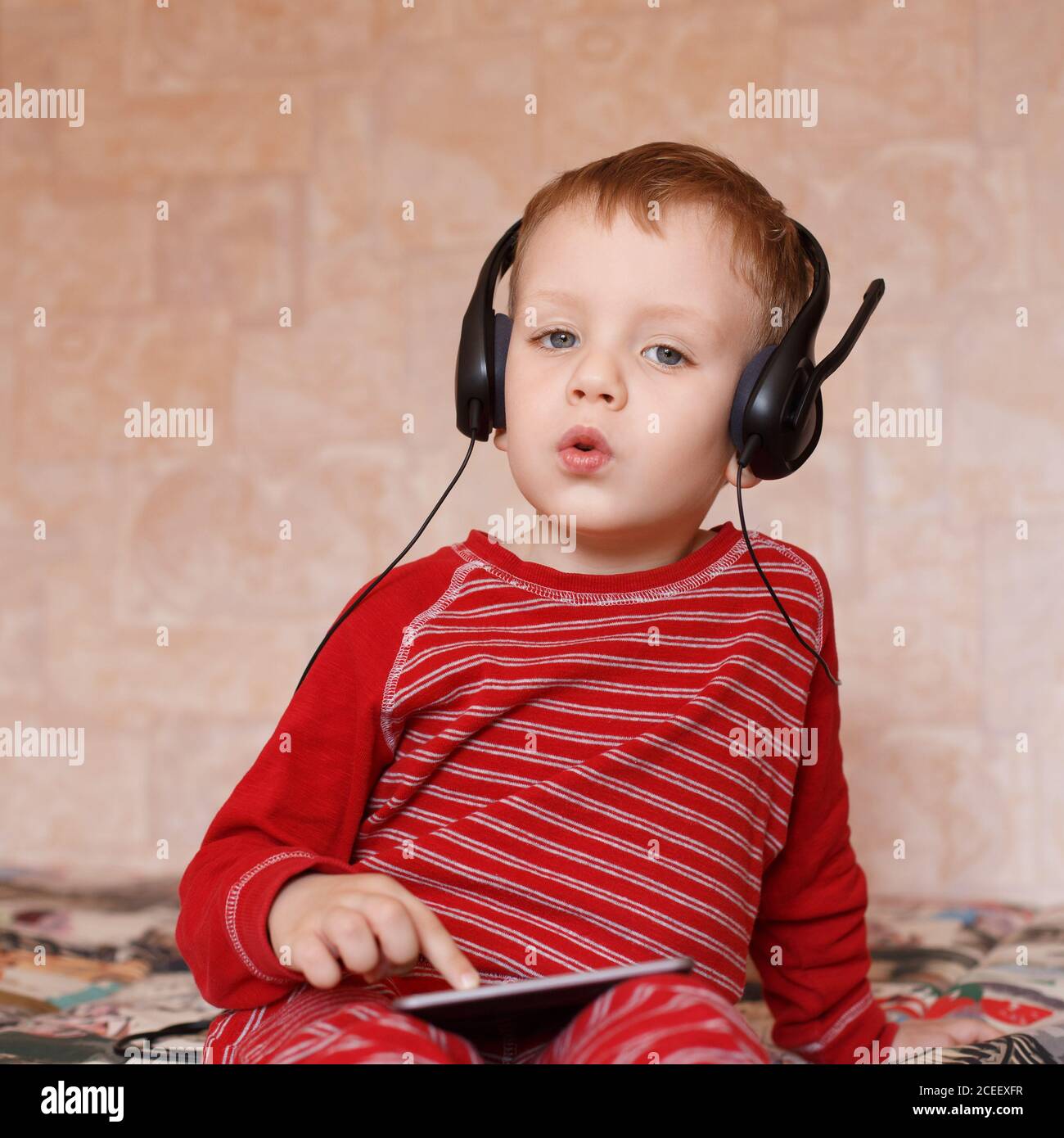 Little boy with headphones listening to music and singing Stock