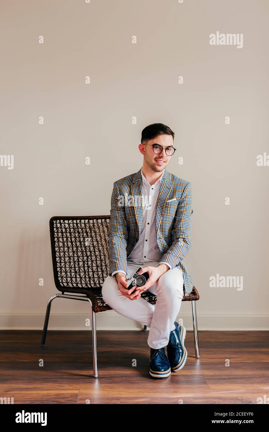 Trendy young man sitting chair hi-res stock photography and images - Alamy