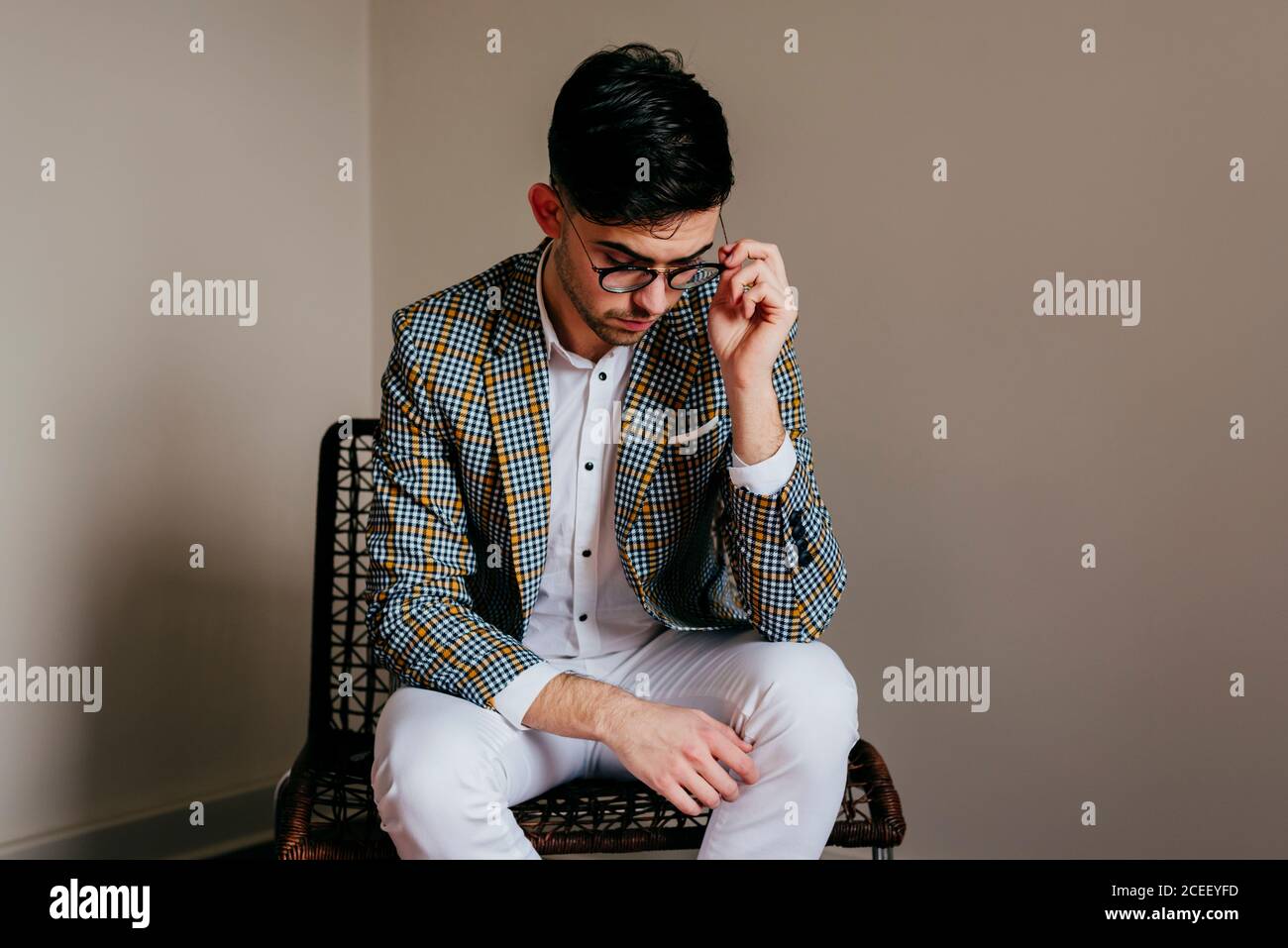 Thoughtful stylish young man on chair Stock Photo