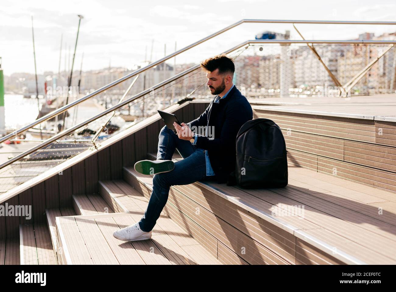 Stylish man using tablet in port Stock Photo