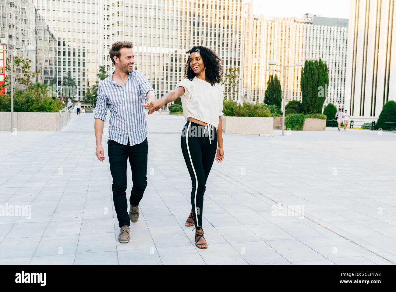 holding hands couple walking on street Stock Photo