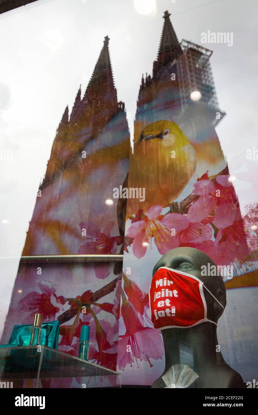 breathing mask with printed sloagen 'I am fine' in the store window of the Cologne Tourist Shop near the Cathedral, reflection of the Cathedral, Colog Stock Photo